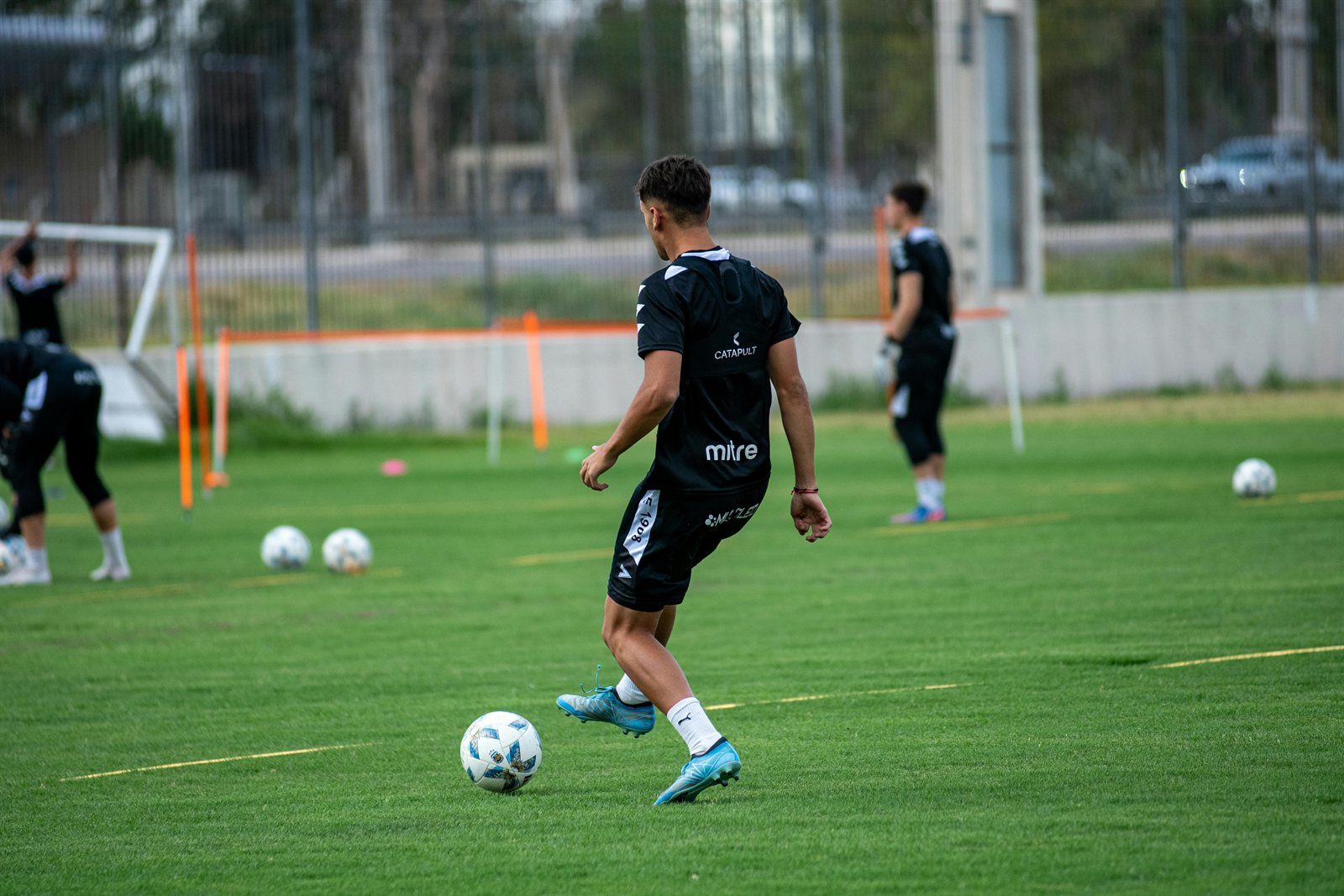 Joueur de football en phase d'entraînement avec ballon sur terrain