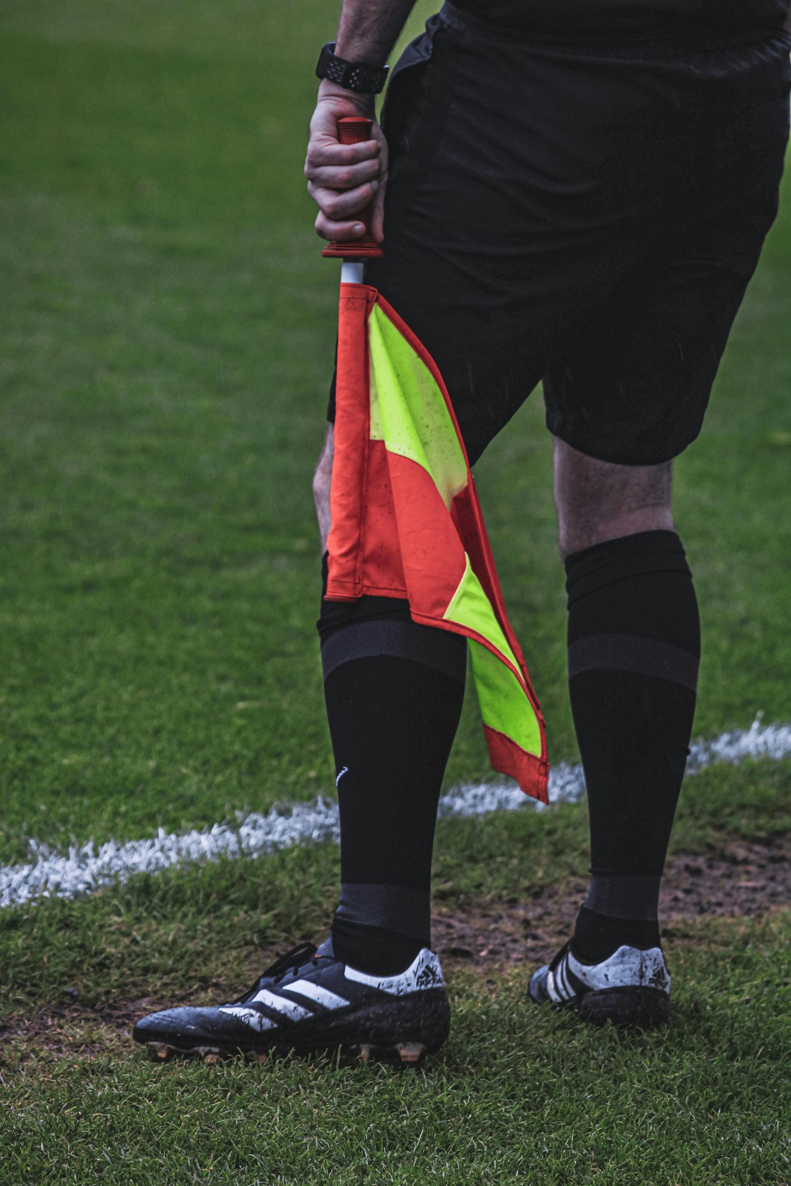 Arbitre assistant tenant un drapeau sur le bord d'un terrain